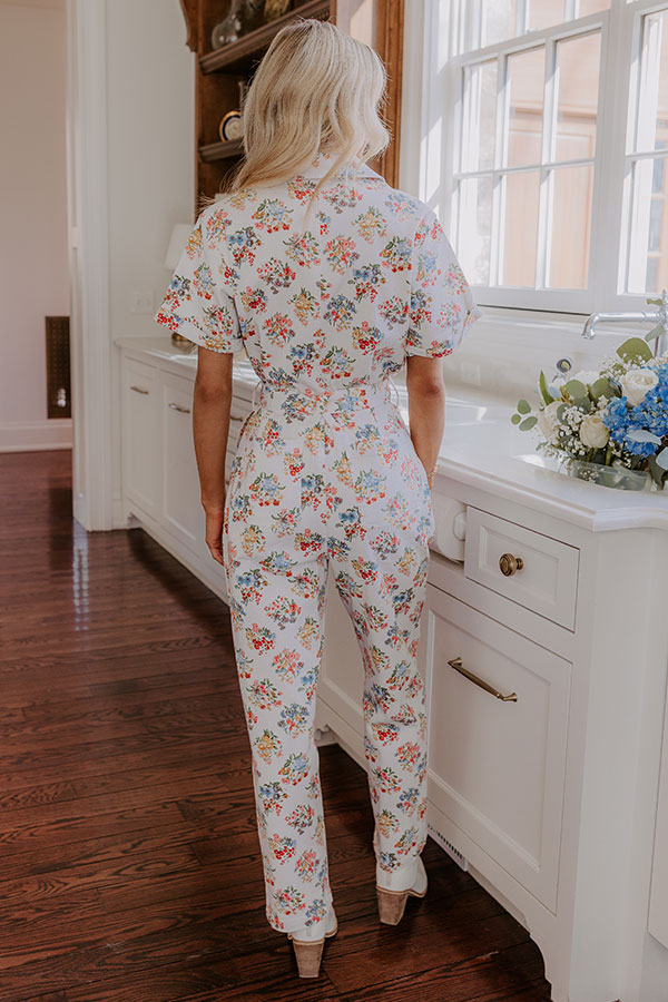 Elegant and effortless winter outfit featuring a short-sleeved floral jumpsuit, ideal for a cozy indoor setting.